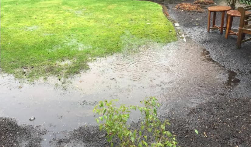 French drain installation in St. Louis yard protecting foundation from water buildup