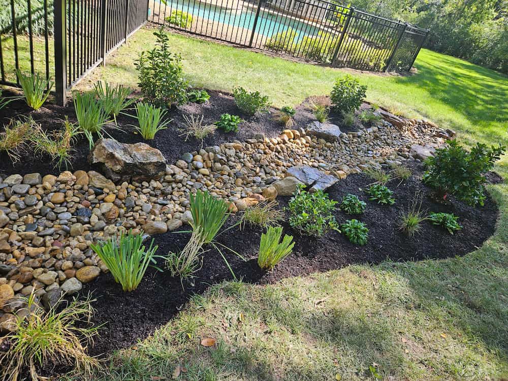 French drain installation in St. Louis yard protecting foundation from water buildup
