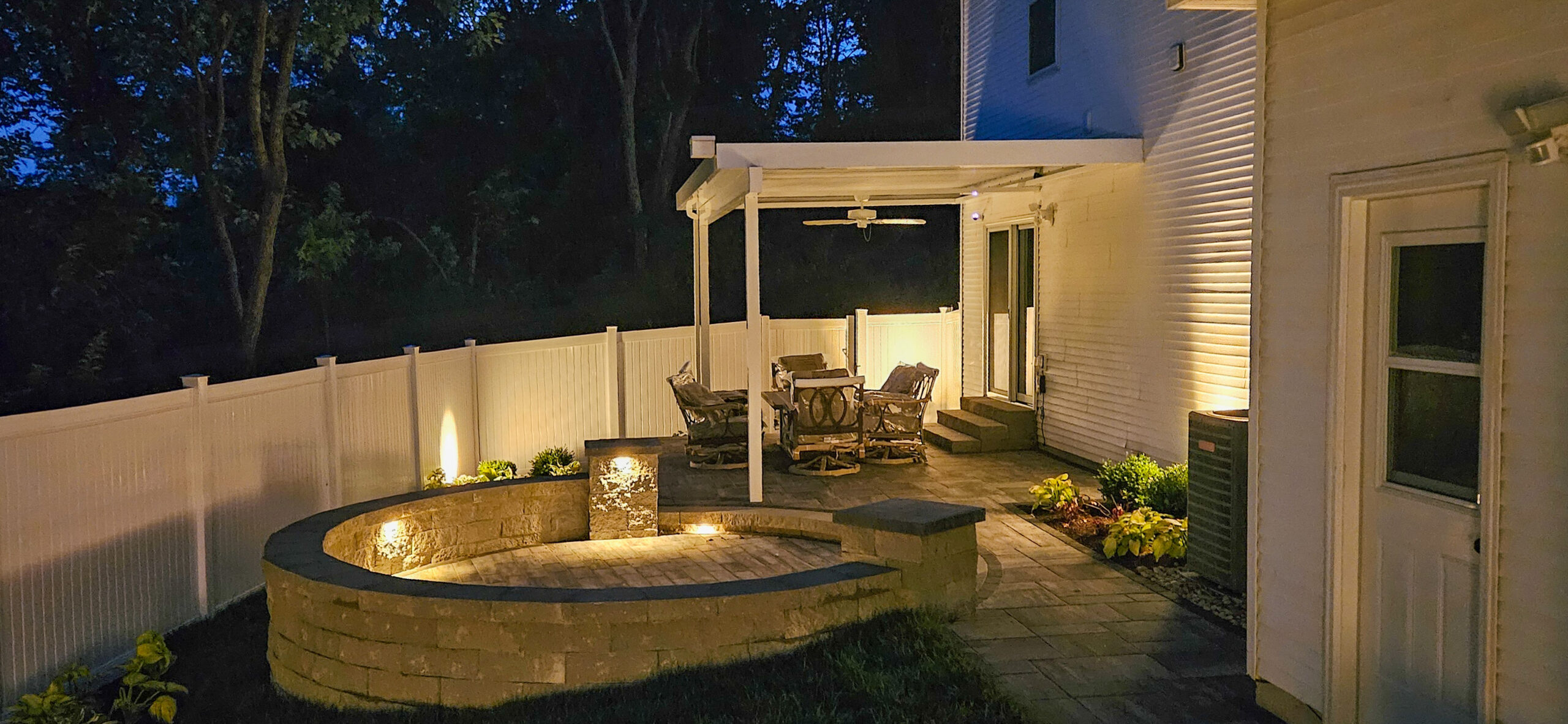 Outdoor lighting on a patio and planting beds after dark