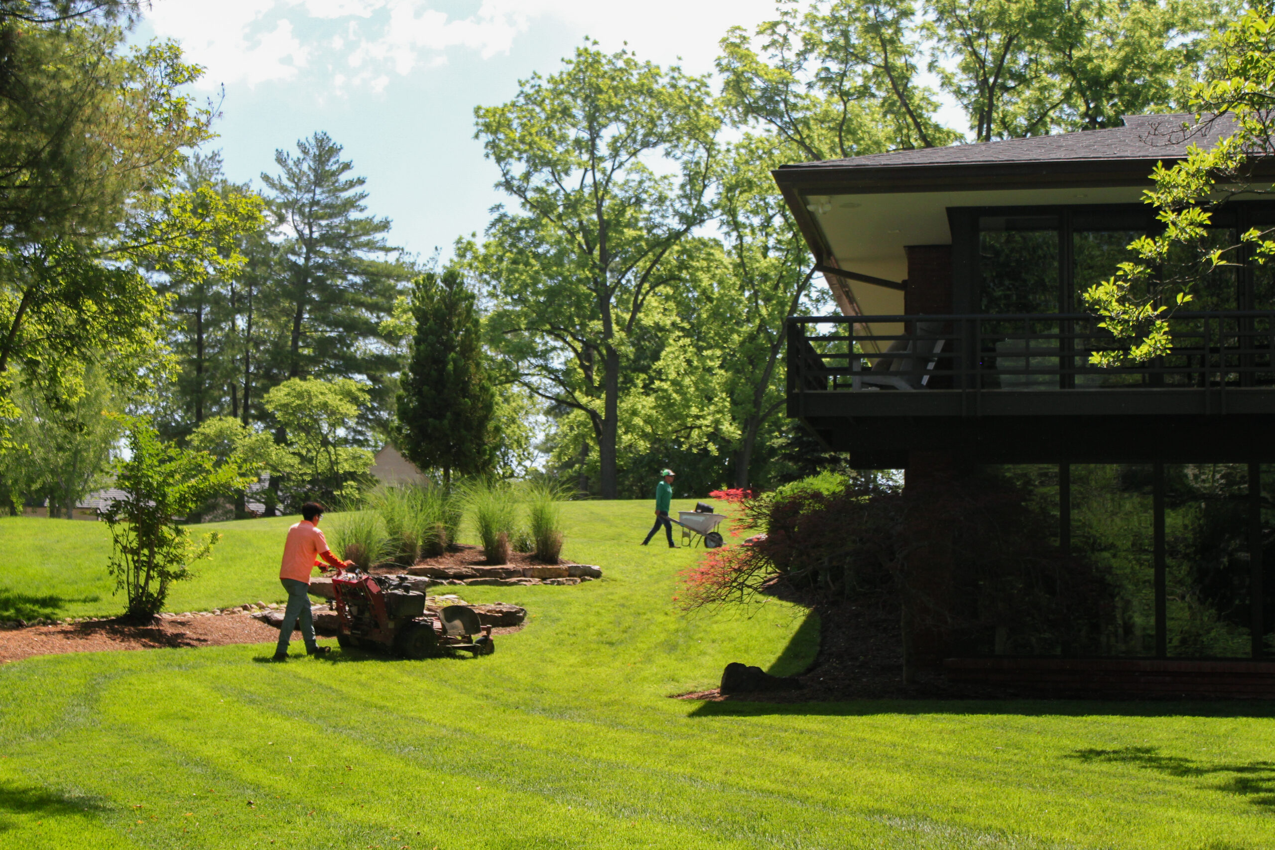 Crew mowing a front lawn